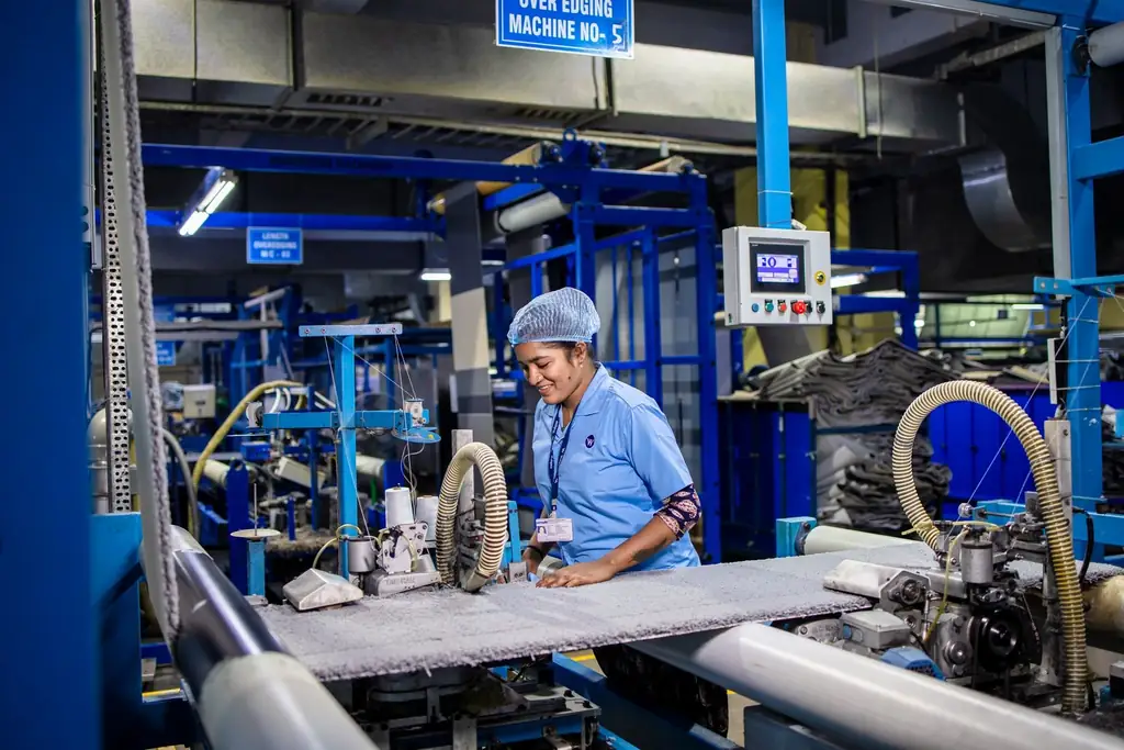 A worker operating machinery on a manufacturing floor