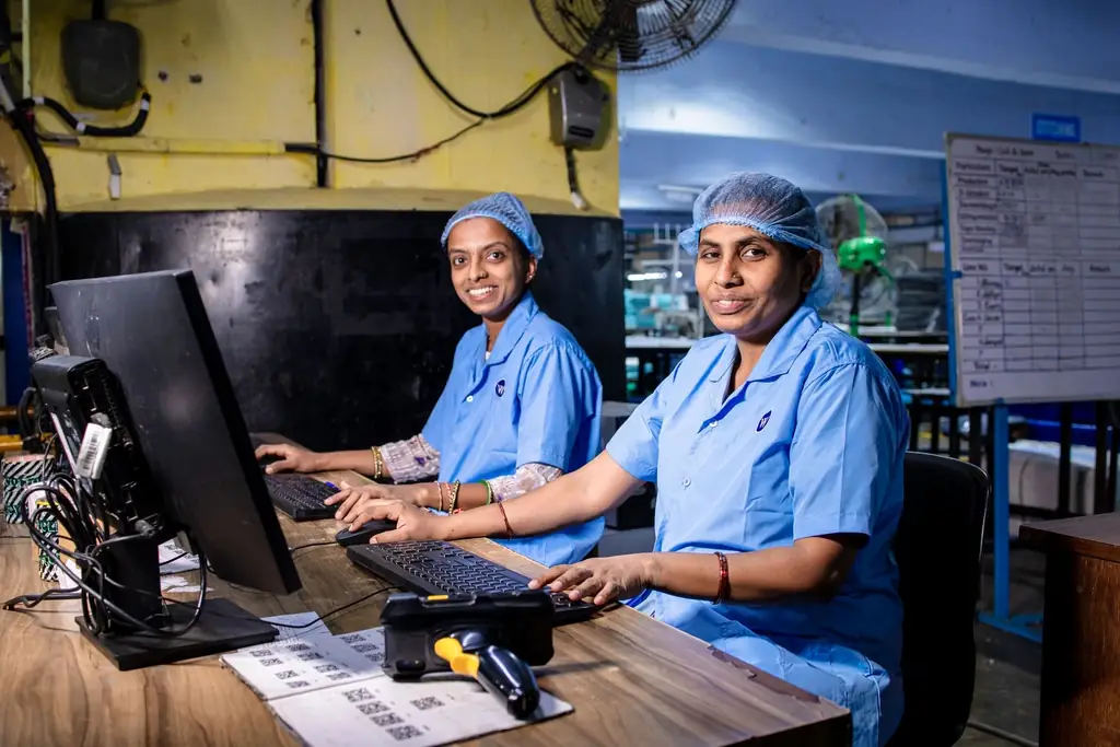 Two colleagues at a computer desk inside a plant