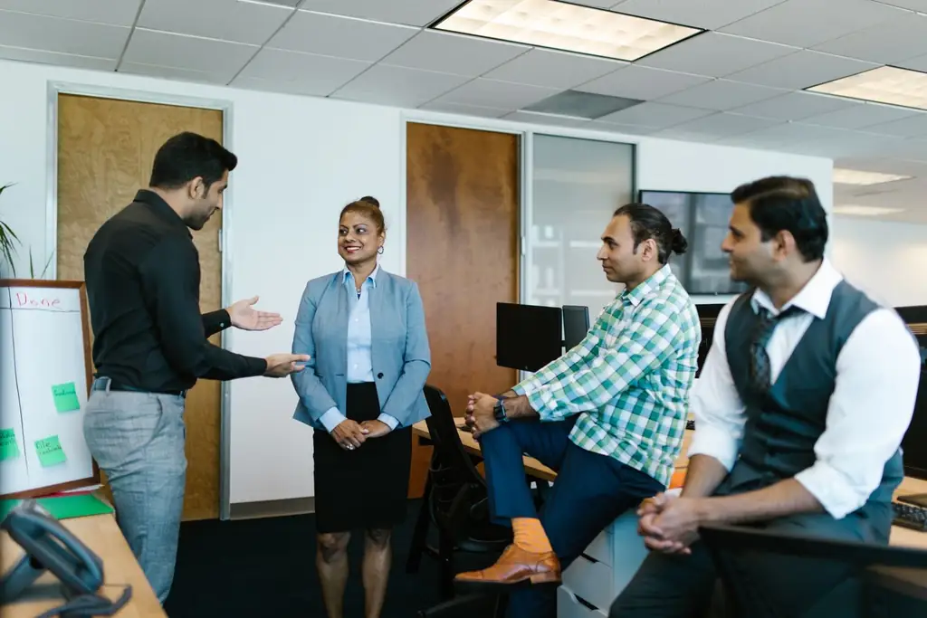 Colleagues in an office discussing work, representing a permanent team